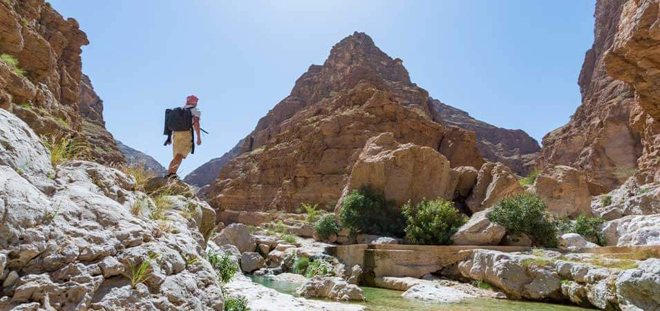 tourist stands in Wadi Shab in Oman